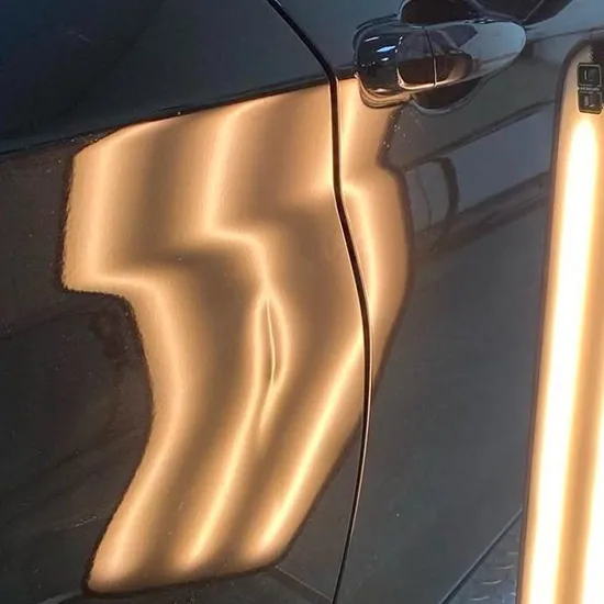 Parkdelle an einer schwarzen Fahrzeugtür vor der Reparatur