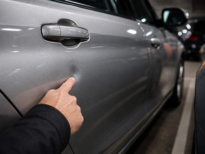 Parkdellen professionell & lackschadenfrei entfernen Parkdelle an einer Fahrzeugtür vor der lackschadenfreien Reparatur